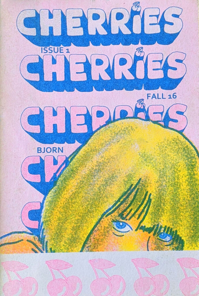 Zine cover, the title "Cherries" repeats in block text against a pink background, while a person with blond hair and blue eyes is partially visible behind a bottom border of a repeating cherry pattern. 