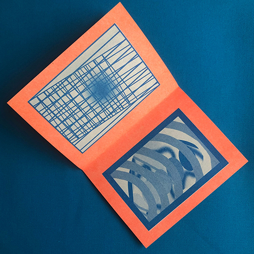 Open spread of a zine with orange borders and abstract blue drawings inside. 