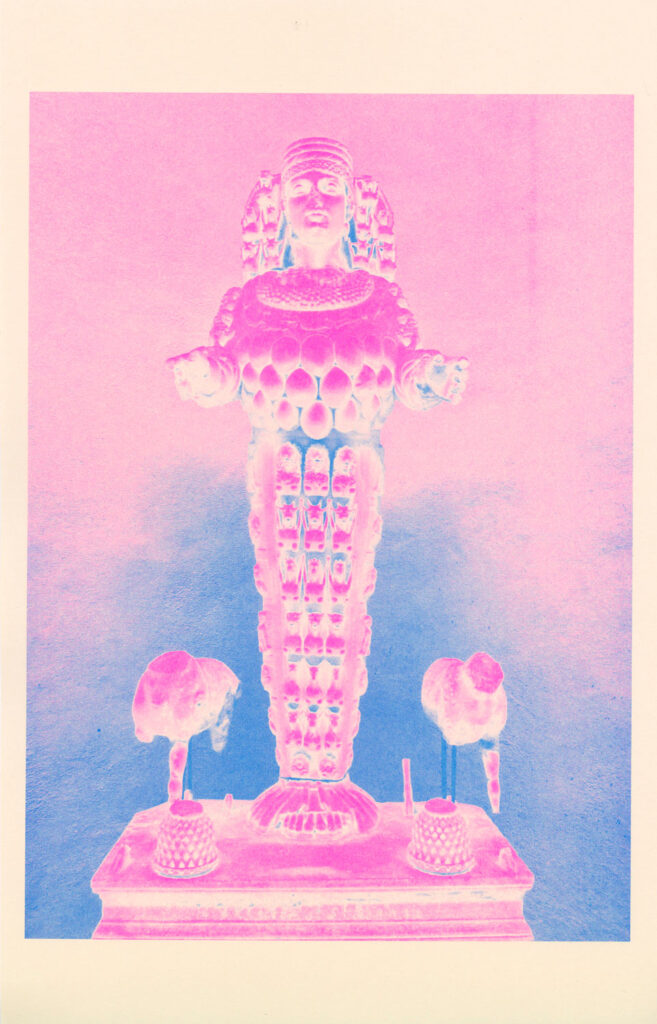 A statue of a figure that appears to be religious printed in pink and blue. 