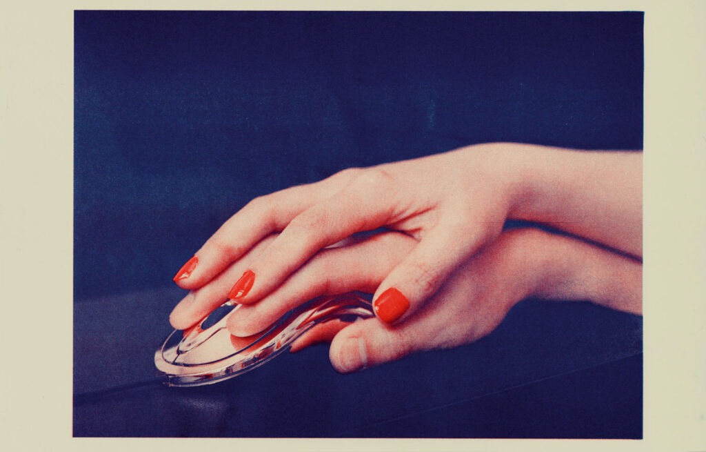 Riso print of a photograph of a pale hand with red nails on top of another pale hand, that is on top of a metallic computer mouse, against a dark background. 