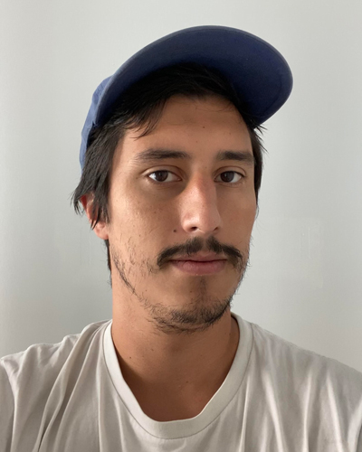 Photo of Andrew Alexander, wearing a baseball cap, with dark hair and a mustache.