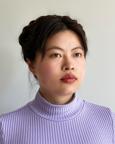 Photograph of Ivy Chen, her dark hair is tied back and she wears a purple turtleneck.
