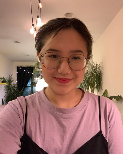 Photo of Sarula Bao, who has dark hair pulled back, and wears glasses and a purple shirt.