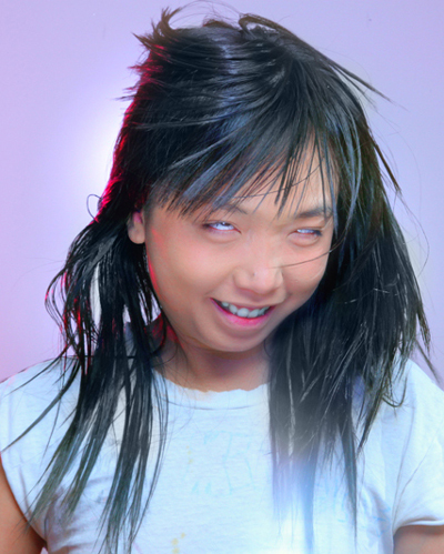 Photo of Thu Tran rolling her eyes, whose black hair waves in motion around her.