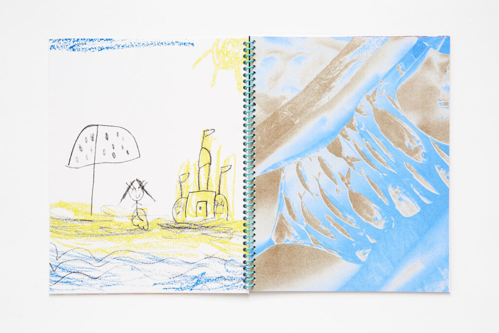 Double page spread, left page is a child's drawing of a beach scene with an umbrella, child figure, and a sandcastle, right page is a gold and aqua duotone photo of a female torso wearing a one piece fish patterned bathing suit.