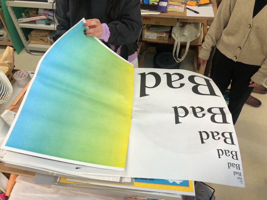A large scale printed newspaper showing text and a color gradient