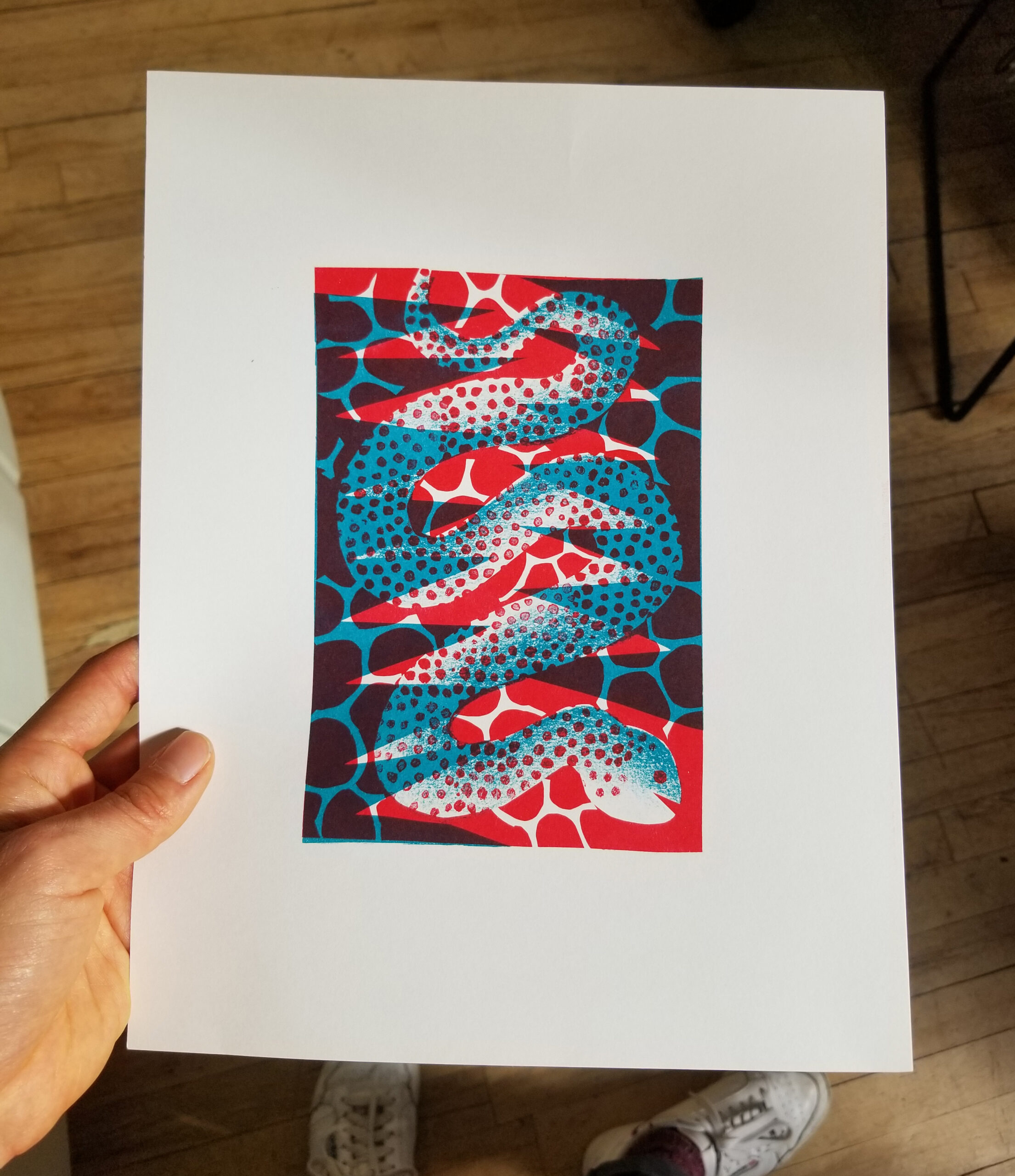 Riso printed illustration of a blue and red snake in a childlike, playfully exaggerated style.