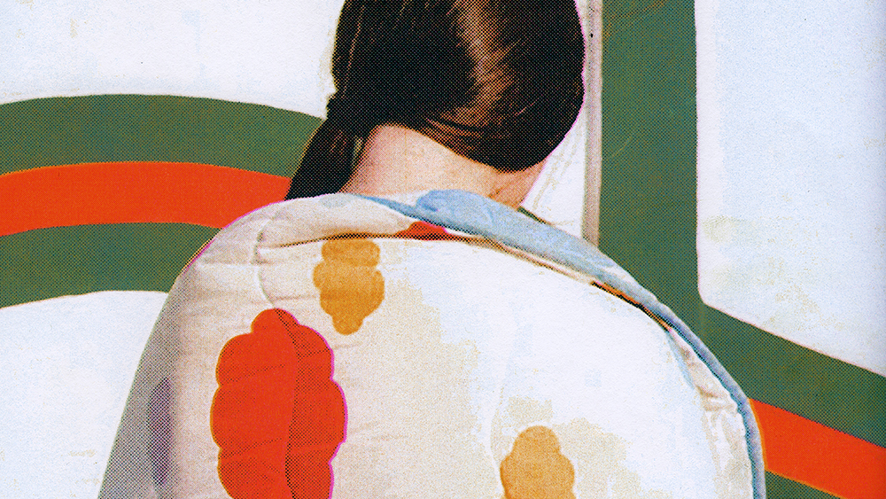 Photograph of the back of a person, brown hair tied into a low ponytail and wearing a puffy quilted jacket. The background is saturated orange and green stripes on a white background.